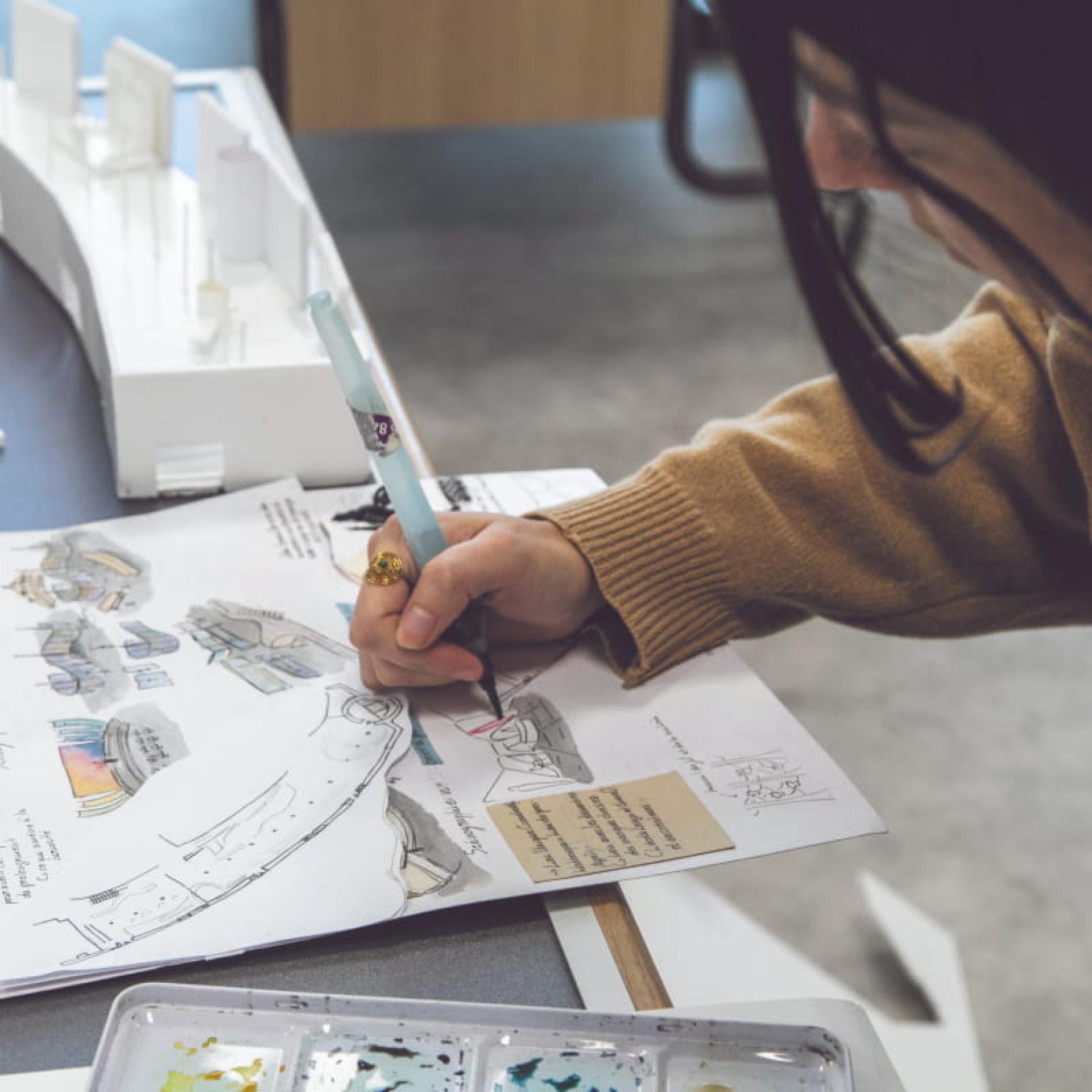 Étudiante travaillant sur la conception d’un scénario d’usage sur papier.